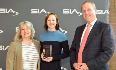 Amanda Conley accepting her award at SIA GovSummit, alongside SIA Women in Biometrics Awards presenters Cathy Tilton and Benji Hutchinson