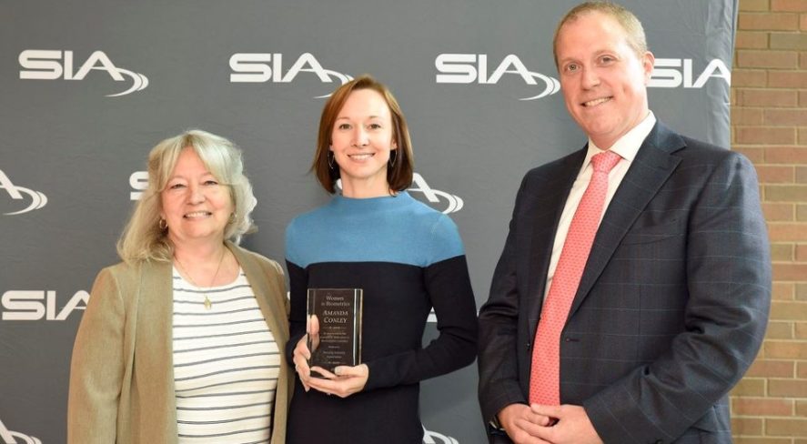 Amanda Conley accepting her award at SIA GovSummit, alongside SIA Women in Biometrics Awards presenters Cathy Tilton and Benji Hutchinson