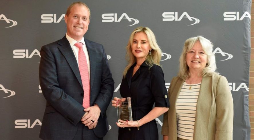 Delia McGarry accepting her award alongside SIA Women in Biometrics Awards presenters Benji Hutchinson and Cathy Tilton