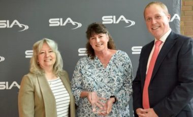 Diane Stephens accepting her award alongside SIA Women in Biometrics Awards presenters Benji Hutchinson and Cathy Tilton