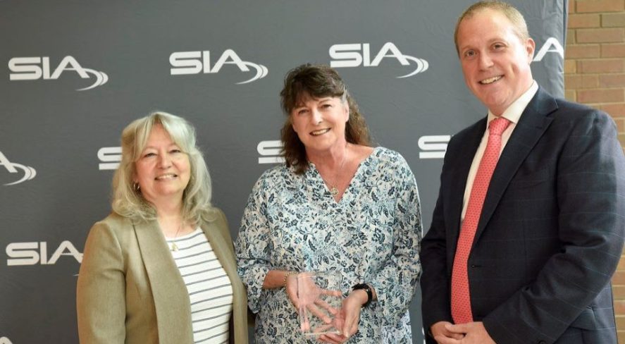 Diane Stephens accepting her award alongside SIA Women in Biometrics Awards presenters Benji Hutchinson and Cathy Tilton