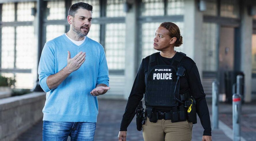 police officer and man walking inside building